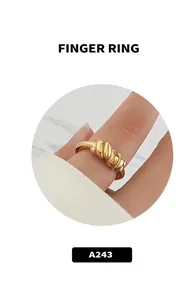 Dettaglio di un anello in titanio placcato oro 18k con trama a spirale intrecciata al dito