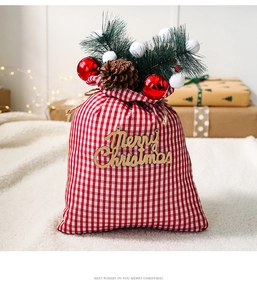 Detail of red and white plaid Christmas gift bag with pine cones and festive ornaments