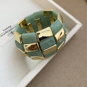 Close-up of marble texture resin and golden metal blocks on a chunky elastic bracelet