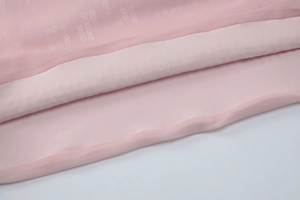 Detailansicht des rosa Paillettenkleid-Saums mit Mesh-Overlay und feiner Verarbeitung