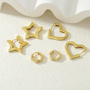 Detailed view of gold geometric earrings set featuring star, heart and hexagon shapes