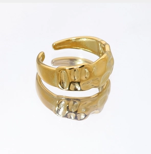 Dettaglio anello in acciaio inossidabile placcato oro 18K con texture martellata e riflesso