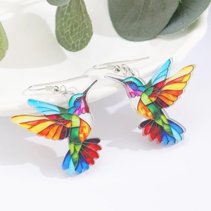 Detalle de pendientes de colibrí en acrílico colorido con efecto de vidriera vibrante
