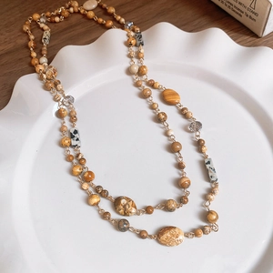 Macro detail of geometric beaded necklace with natural stone textures and gold accents