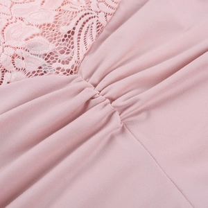 Macro shot of elegant pink lace fabric with intricate patterns and soft pleats on jumpsuit
