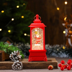 Close-up of a red Christmas lantern with a Santa Claus figure and swirling glitter snow
