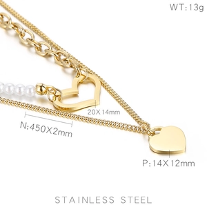Detail view of double-layered gold stainless steel heart necklace with pearl chain