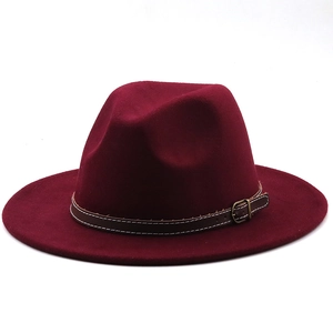 Detail of wine red wool fedora hat featuring a brown leather band and metal buckle