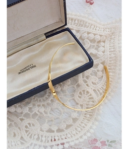 Detail of twisted 18k gold plated stainless steel cuff bracelet on vintage navy box