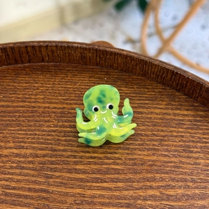 Détail d'une mini pince à cheveux pieuvre avec motif de marbre vert en acétate