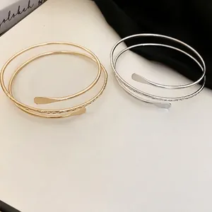 Minimalist multi-layer spiral open bracelets in gold and silver with hammered texture