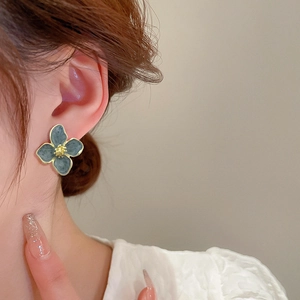 S925 silver flower stud earrings in grey-green enamel with gold trim on a model
