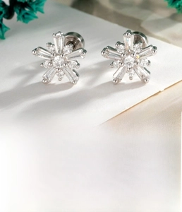 Macro shot of silver snowflake cartilage studs with cubic zirconia and flat screw back