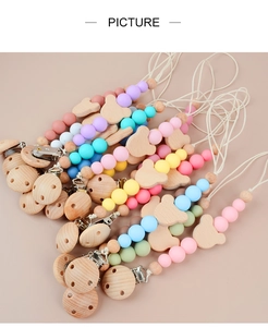 Macro shot of assorted baby pacifier clips featuring silicone beads and wooden bear charms