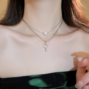 Close-up of double-layer necklace featuring a pearl, gradient butterfly, and star pendant
