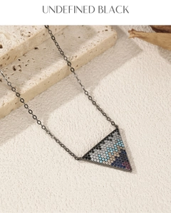 Close-up of S925 silver retro triangle pendant with colorful gemstones on a black chain