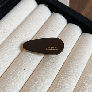 Gros plan sur la barrette en acrylique marron avec lettrage France Handmade doré