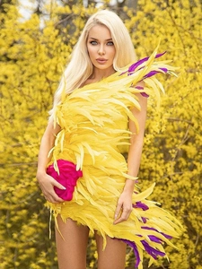 Détails de plumes jaunes avec accents violets sur une robe de soirée asymétrique