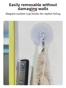 Strong transparent vacuum suction hook holding a towel and comb on a clean wall