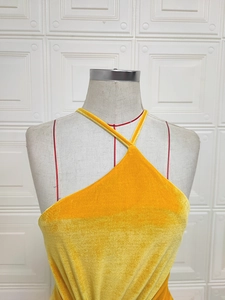 Vue détaillée d'une robe dos nu en velours jaune vif brillant avec texture premium