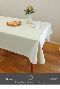 Macro shot of waterproof cream-white faux leather tablecloth with fine texture on wooden table