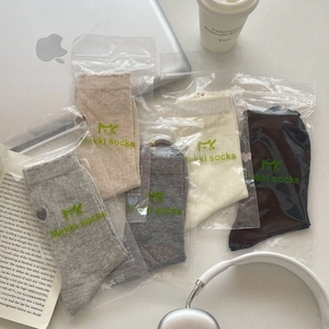 Detail of five pairs of cotton knit socks in neutral tones with minimalist packaging