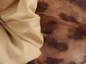 Detailed comparison of smooth beige fabric and exotic brown leopard print silk texture