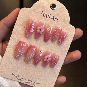 Macro view of 3D butterfly and pink floral embossed patterns on almond shape press-on nails