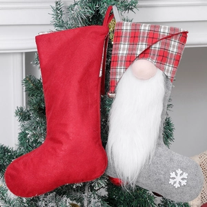 Christmas stocking set with grey gnome and red felt hanging on a green Xmas tree