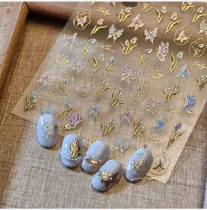 Dettaglio degli adesivi per unghie con farfalle e tulipani dorati con effetto metallico
