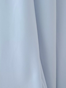 Close-up of light blue silk-satin fabric showing fine texture and natural folds on dress