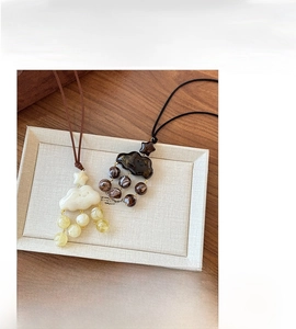 Détail macro du collier pull nuage en résine avec texture marbrée et cordon en velours