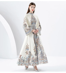Detailed view of the paisley print and bell sleeves on an elegant ivory midi dress