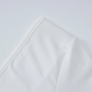 Macro shot of white twill fabric with precision stitching and refined textile texture