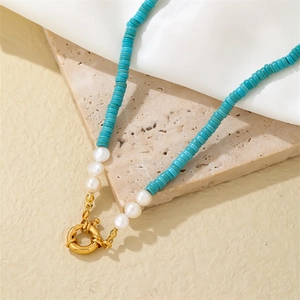 Bohemian stainless steel necklace with turquoise beads and white pearls on marble