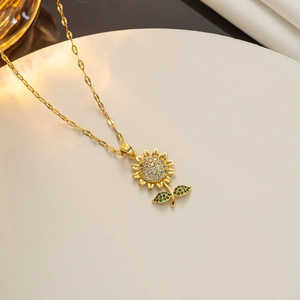 Minimalist sunflower pendant necklace in gold-tone steel with zircon inlay on white stand
