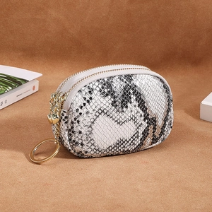Macro detail of python pattern leather coin purse with heart charm and gold keychain