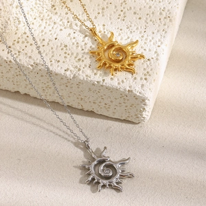 Détail de pendentifs rayons de soleil avec zircon en or et argent sur pierre