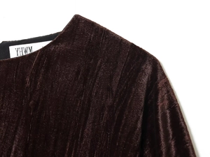Détail de la texture en velours plissé sur l'encolure et l'épaule d'un chemisier chic