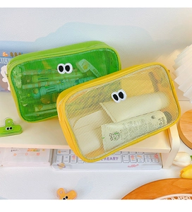 Detail of green and yellow mesh bags with cute eye design on a desk storage rack