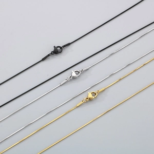 Flat lay of hip-hop snake chain necklaces in black, gold, and silver titanium steel