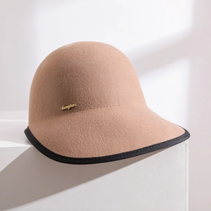 Close-up of khaki wool felt equestrian cap with black trim and gold metal logo