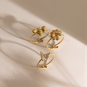 Ensemble de trois bagues plaquées or 18K avec abeille, papillon et marguerite