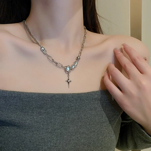 Detail of silver mixed chain necklace with blue round stones and star pendant on model