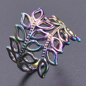 Detail of an adjustable stainless steel ring with rainbow iridescent hollow leaf pattern