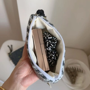 Dettaglio interno di una mini borsa in tweed con fodera e spazio per cosmetici