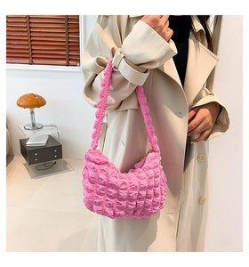 Détail d'un sac hobo rose à texture bulle avec tissu plissé et bandoulière assortie
