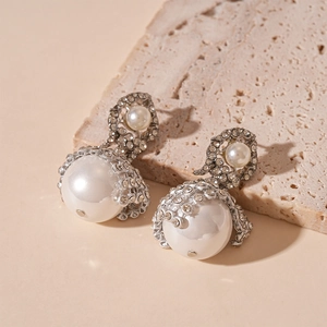 Macro detail of silver mesh earrings with pearls and shimmering pave-set rhinestones
