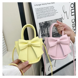 Detail showing two small bow handbags in pink and yellow faux leather for stylish women
