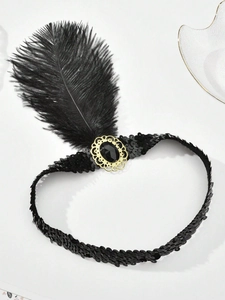 Close-up of 1920s black feather headband with golden brooch and black sequins detail